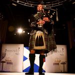 A bagpiper sets the Scottish tone.